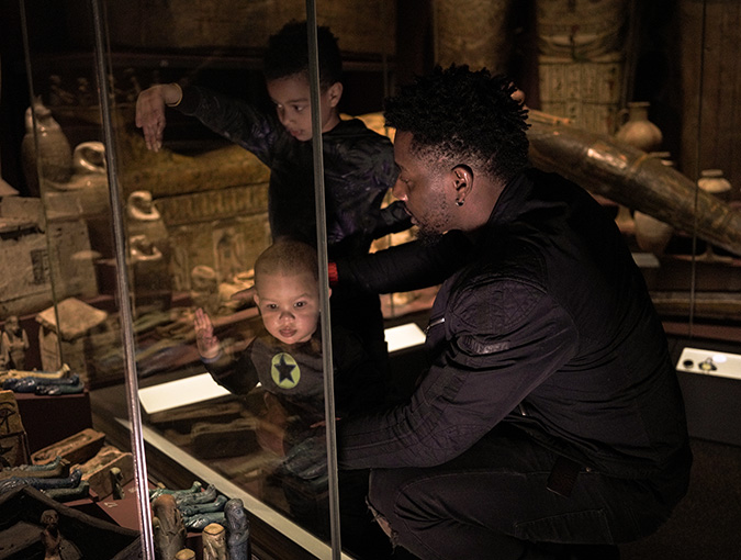 A man and two children visiting the Egypt exhibition